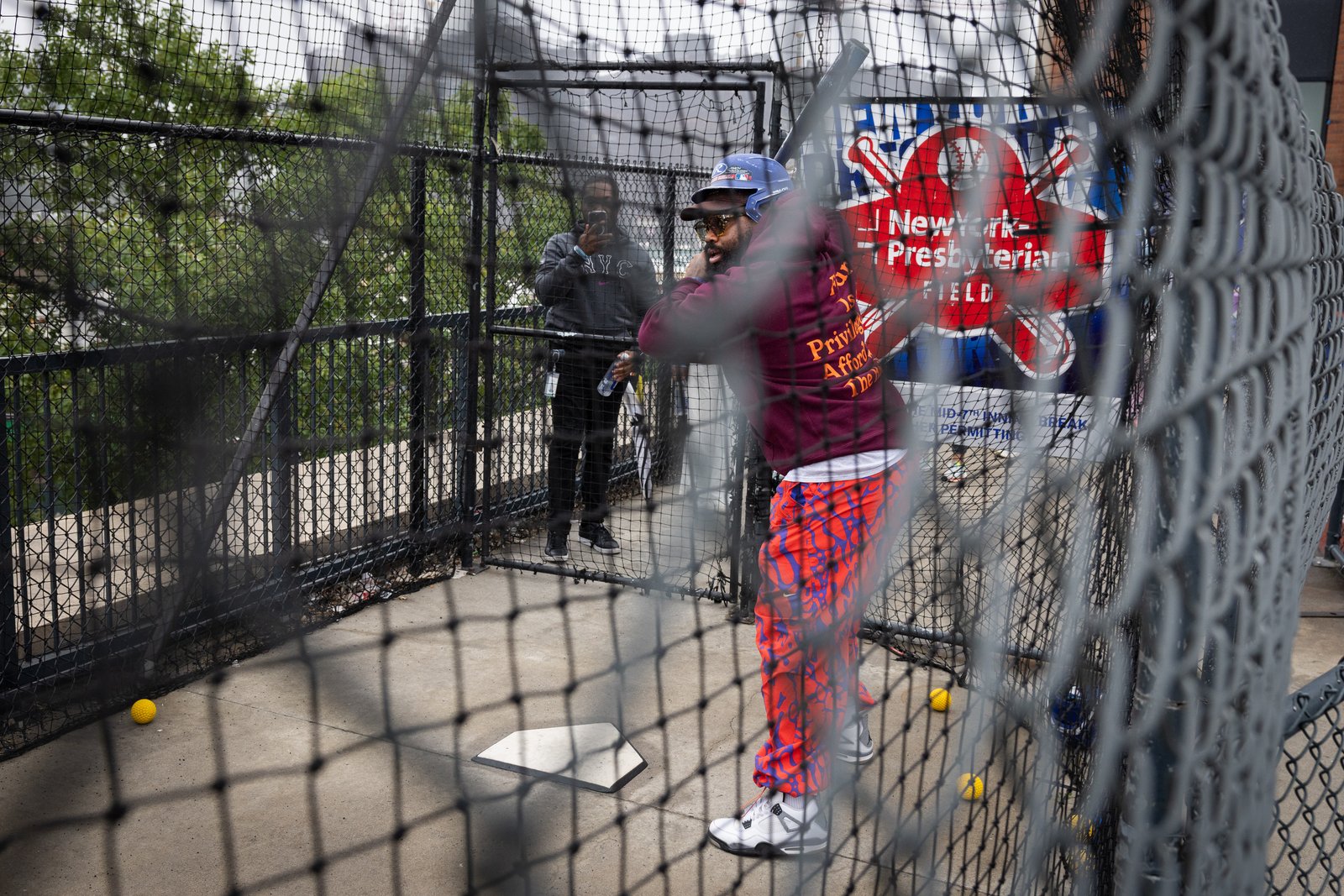 Batting in a stadium batting cage during a team outing