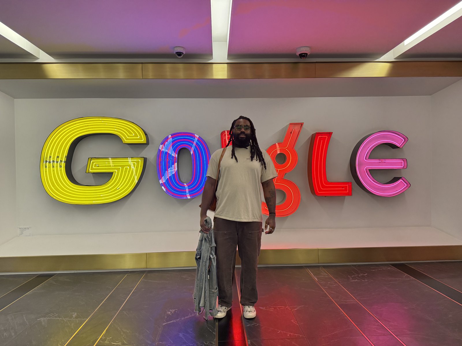 Standing in front of the illuminated Google sign