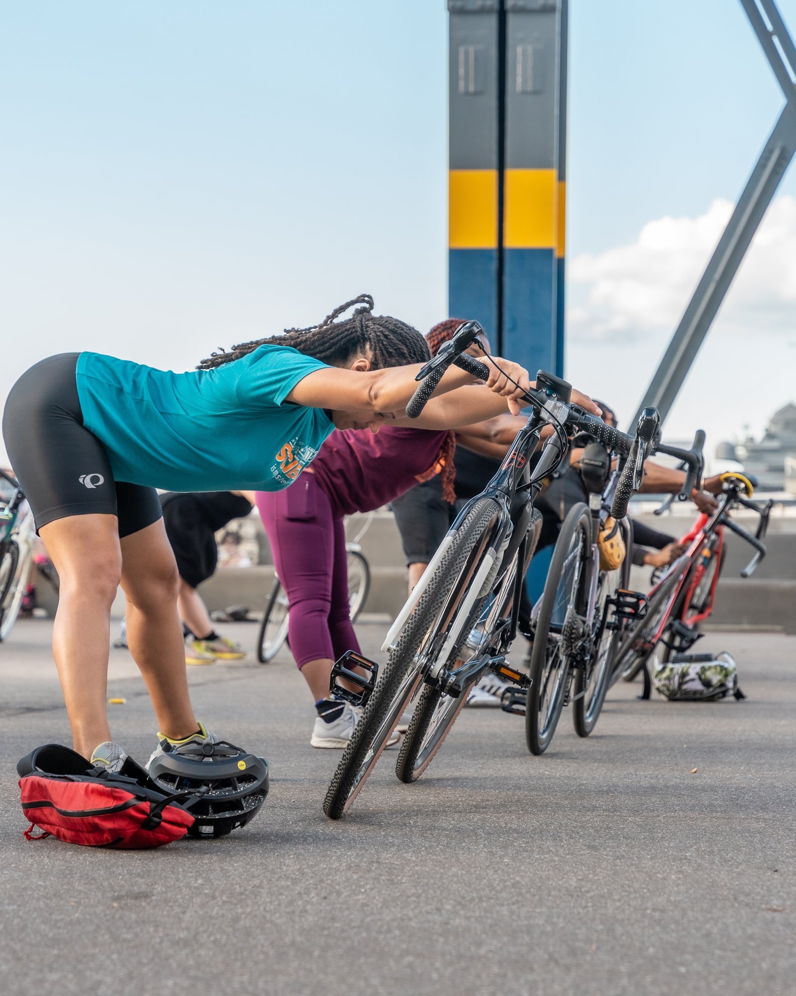 Cyclists stretching using their bike handlebars for support