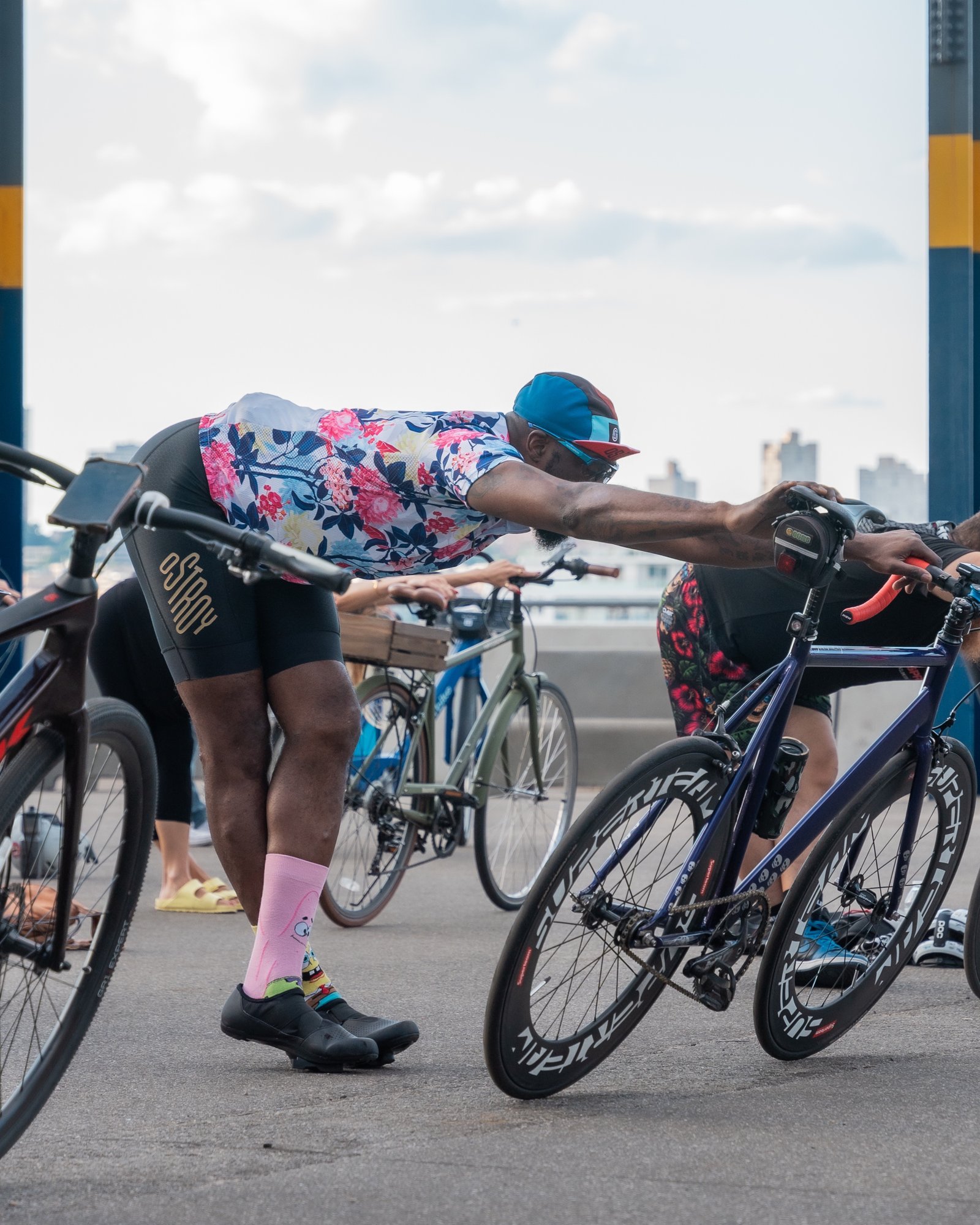 Cyclists using their handlebars to stretch before a group ride
