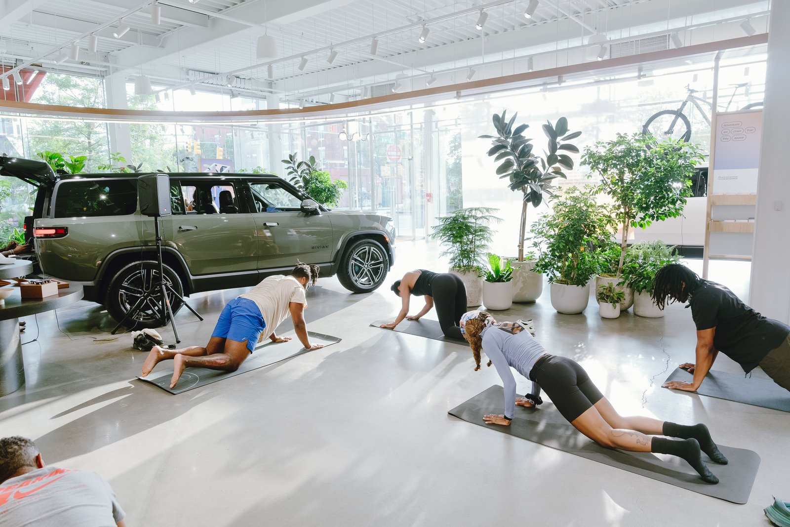 Guiding a downward dog pose for attendees inside the Rivian showroom