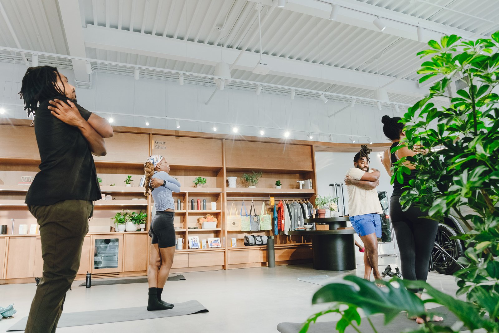 Guiding a seated twist stretch beside the Rivian gear shop shelves