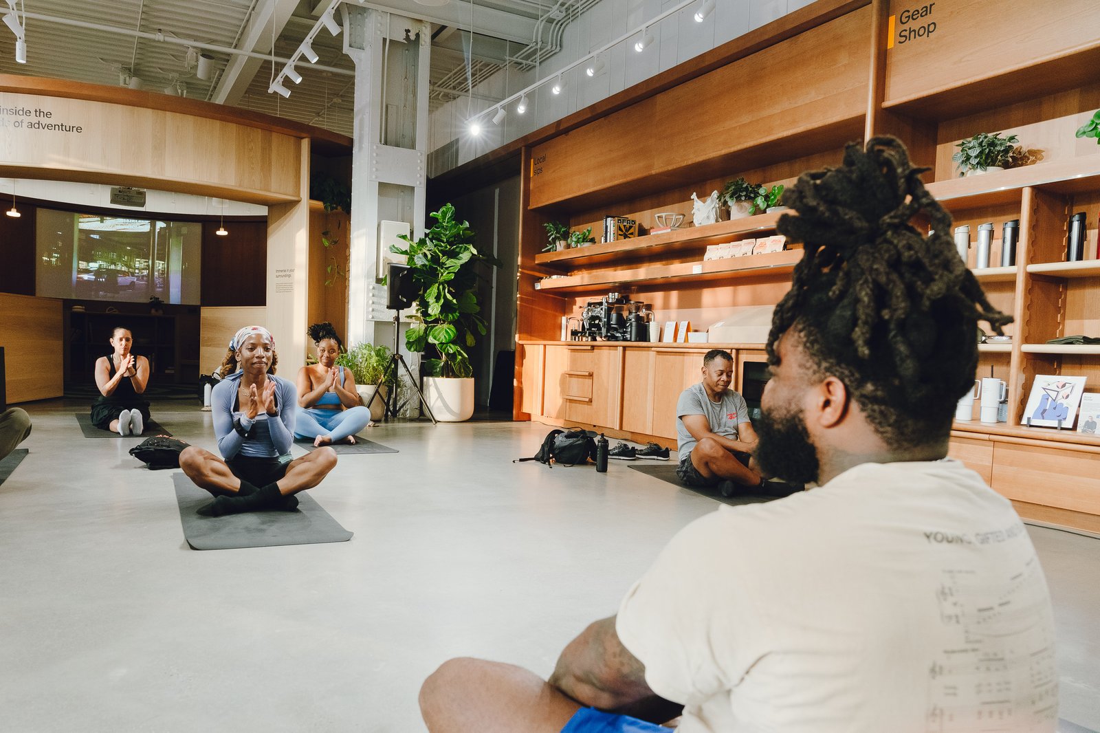 Group seated meditation session inside the Rivian showroom surrounded by retail shelving