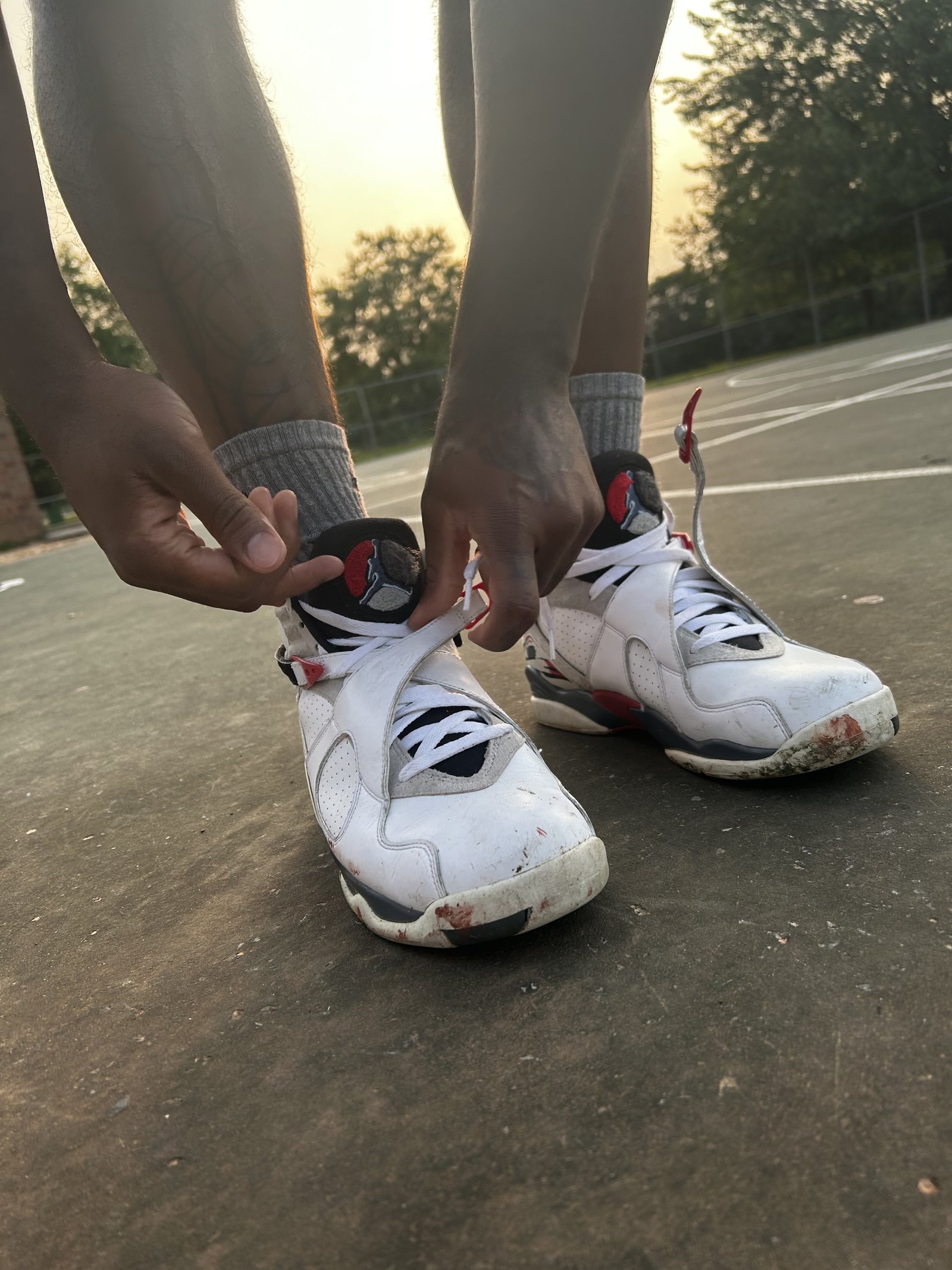 Close-up of tying basketball shoes on an outdoor court