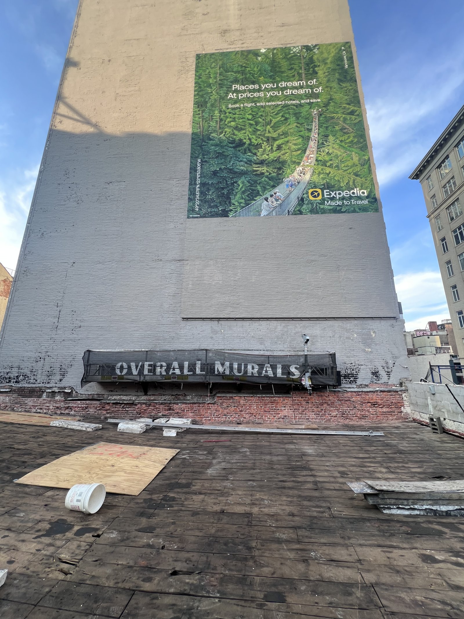 Finished mural on a building with the rig still hanging below